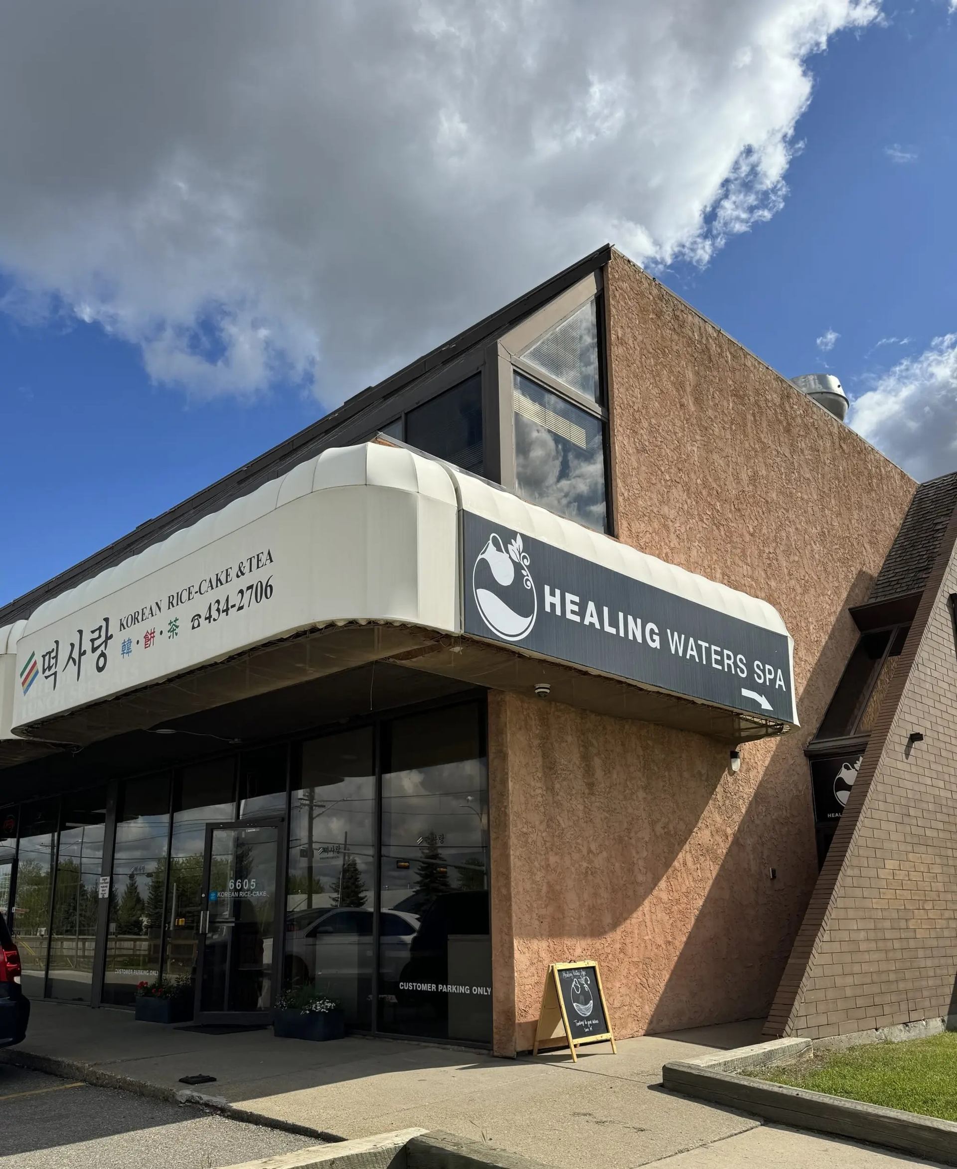 Exterior of the Healing Waters Spa storefront on a sunny day.