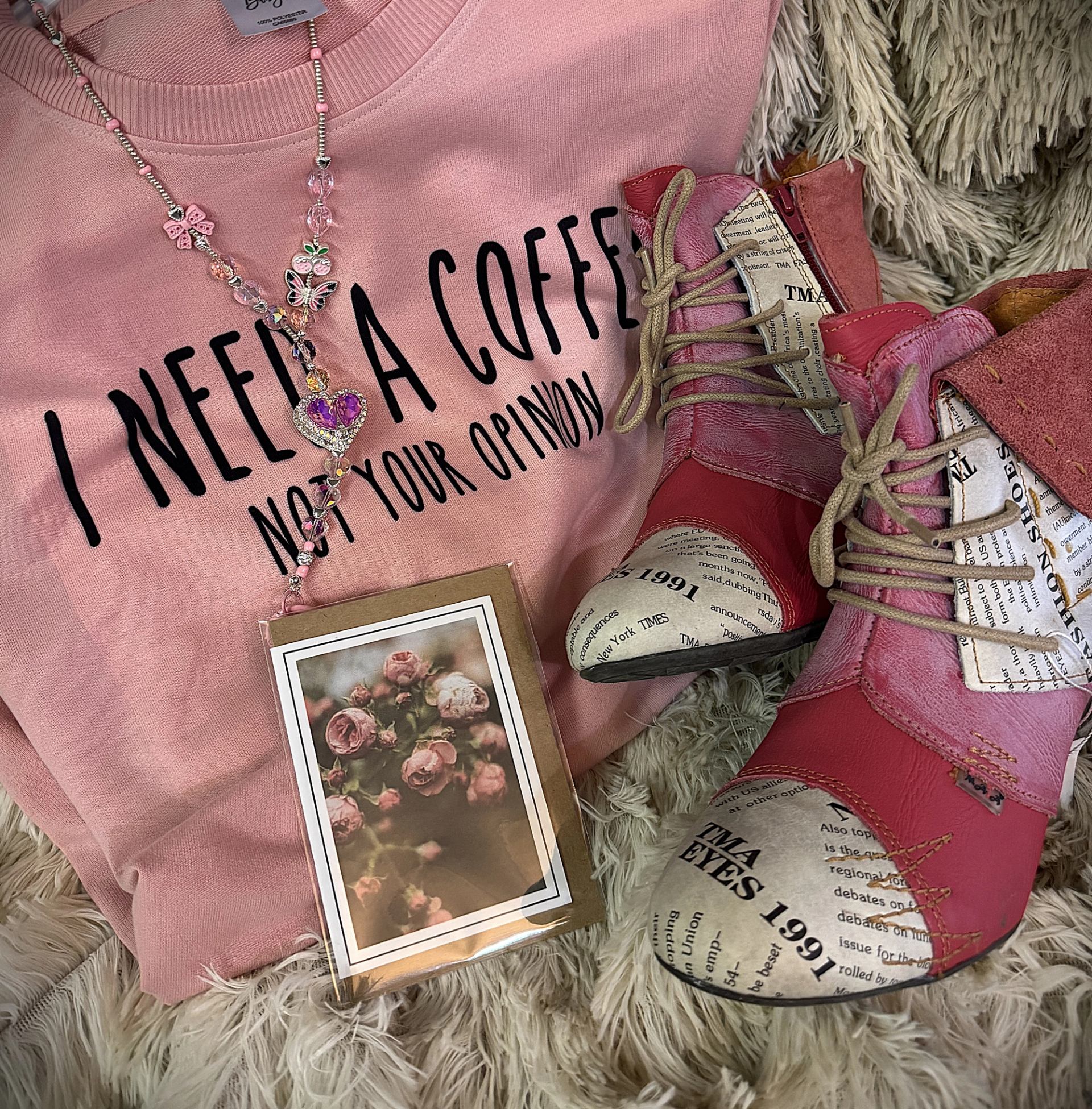 Pink graphic tee, patterned pink boots, floral card, and beaded necklace displayed together.