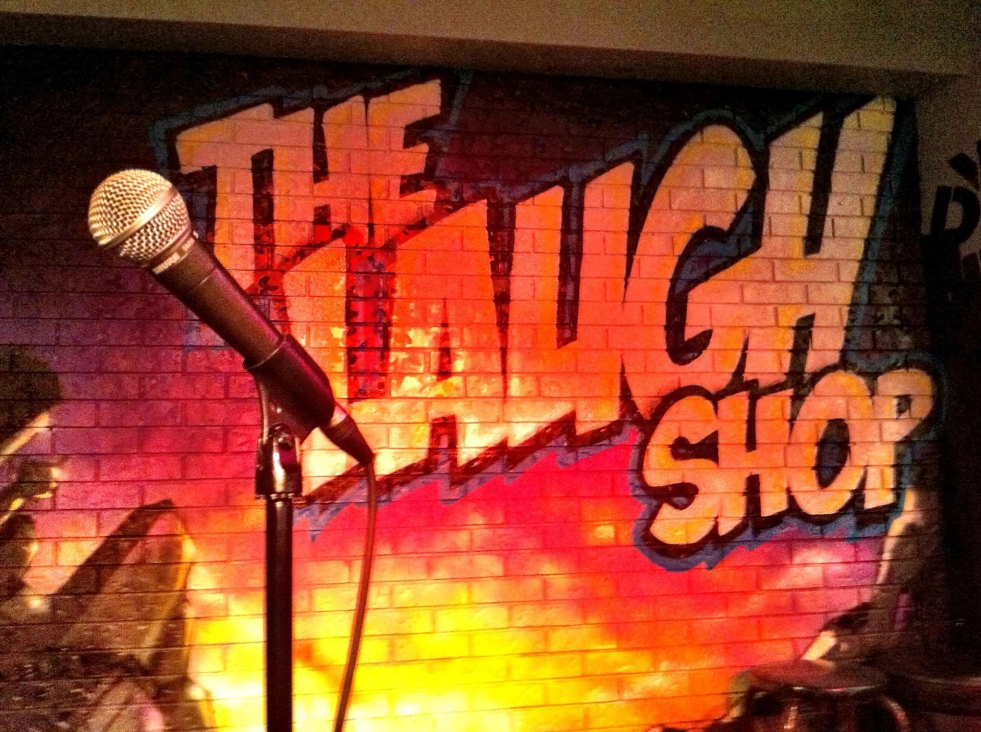 Graffiti brick wall with a microphone and bright lights.