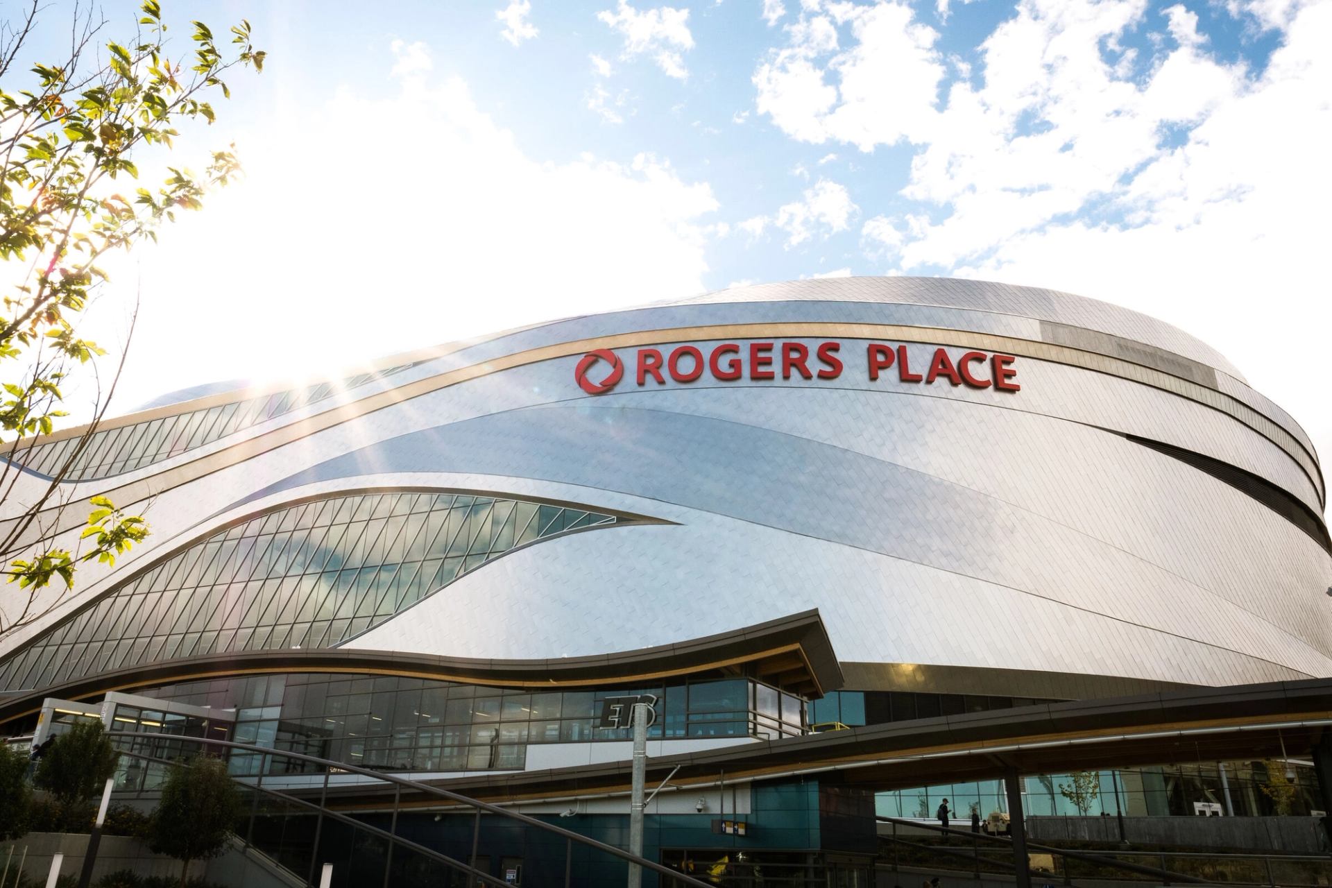 Exterior of Rogers Place in Edmonton with sky and sun in background