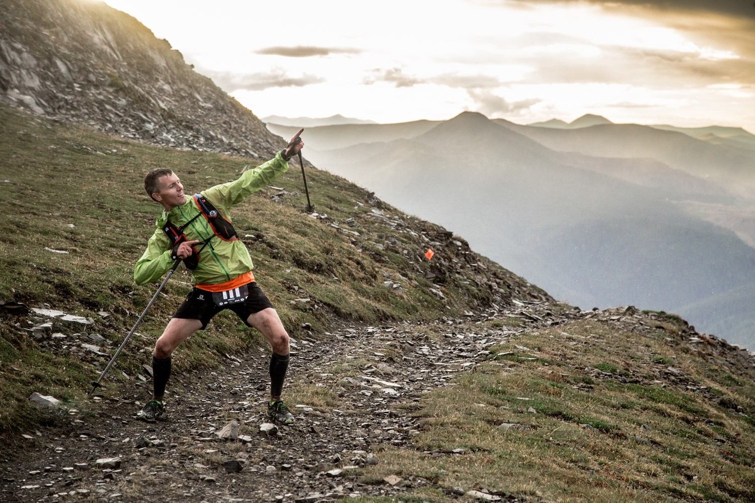 Runner posing triumphantly on mountain trail during Canadian Death Race.