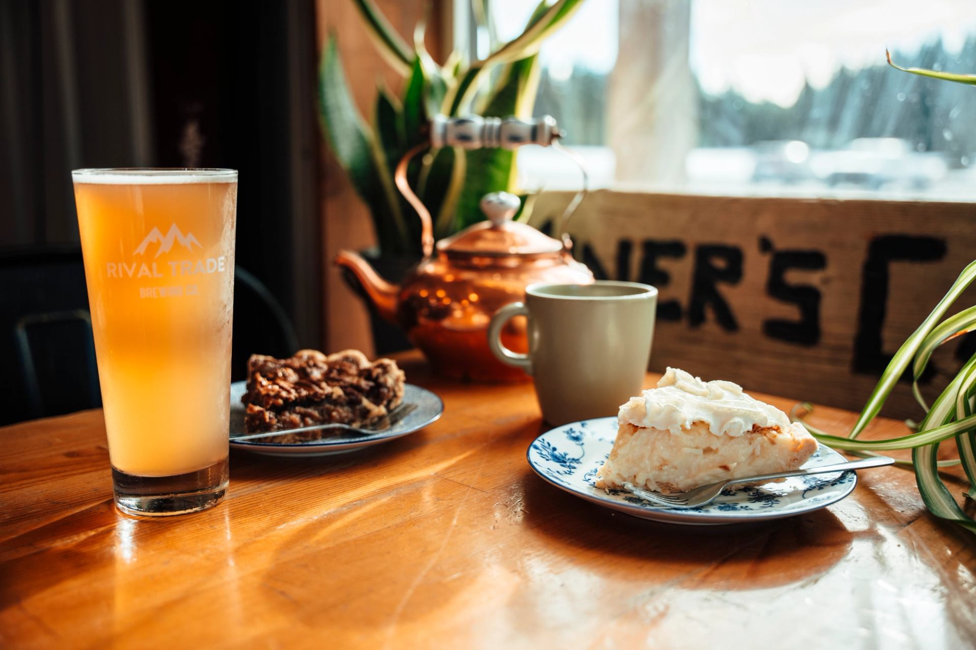 Pie, coffee, and a cold drink on a wooden table inside Miners' Café in Nordegg.