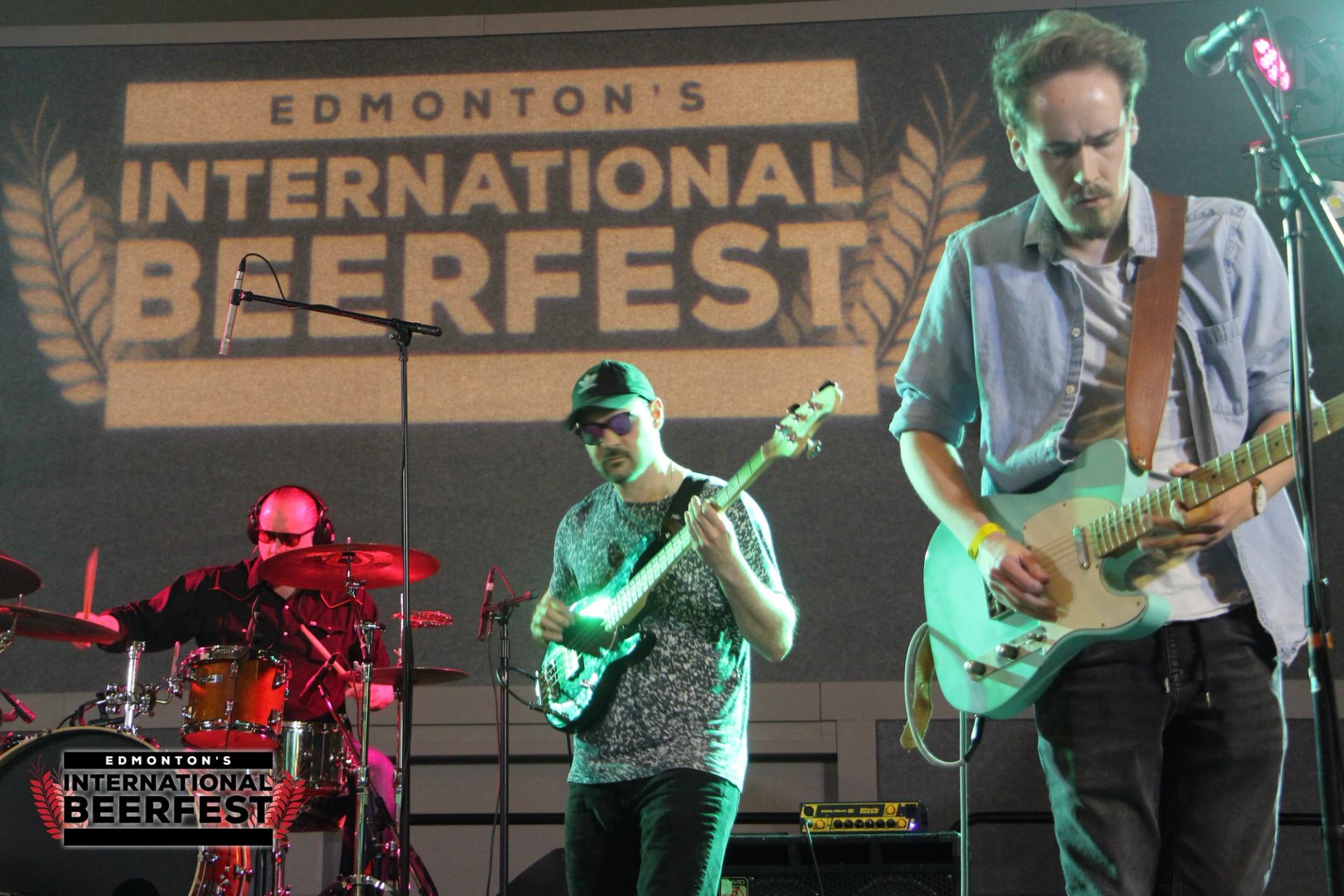 Band performing live at Edmonton’s International Beerfest with guitars and drums on stage.