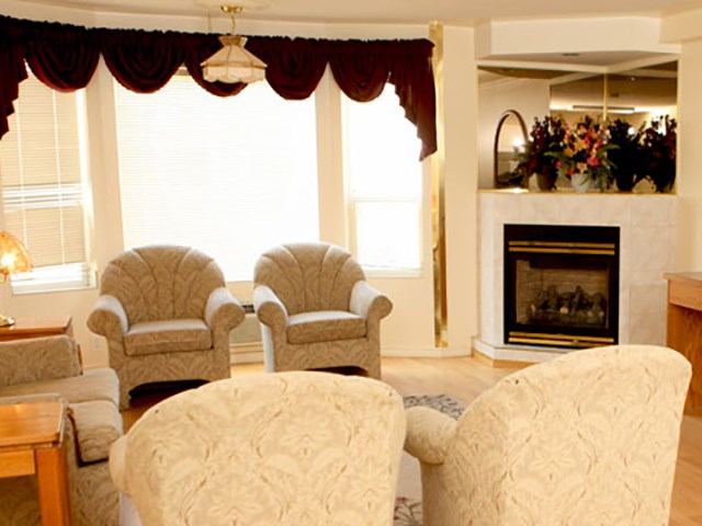 Cozy motel lounge with armchairs, fireplace, and large windows.