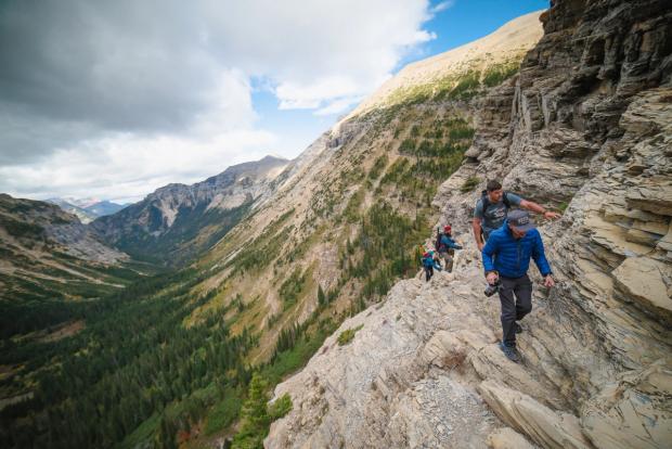 Group of people hiking in the mountains near Crypt Lake in Waterton Lakes National Park.