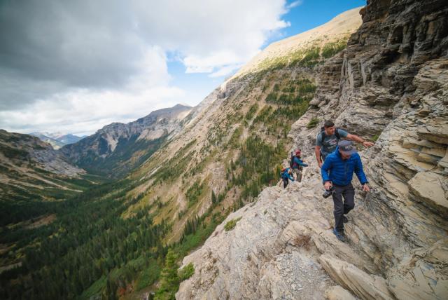 Group of people hiking in the mountains near Crypt Lake in Waterton Lakes National Park.