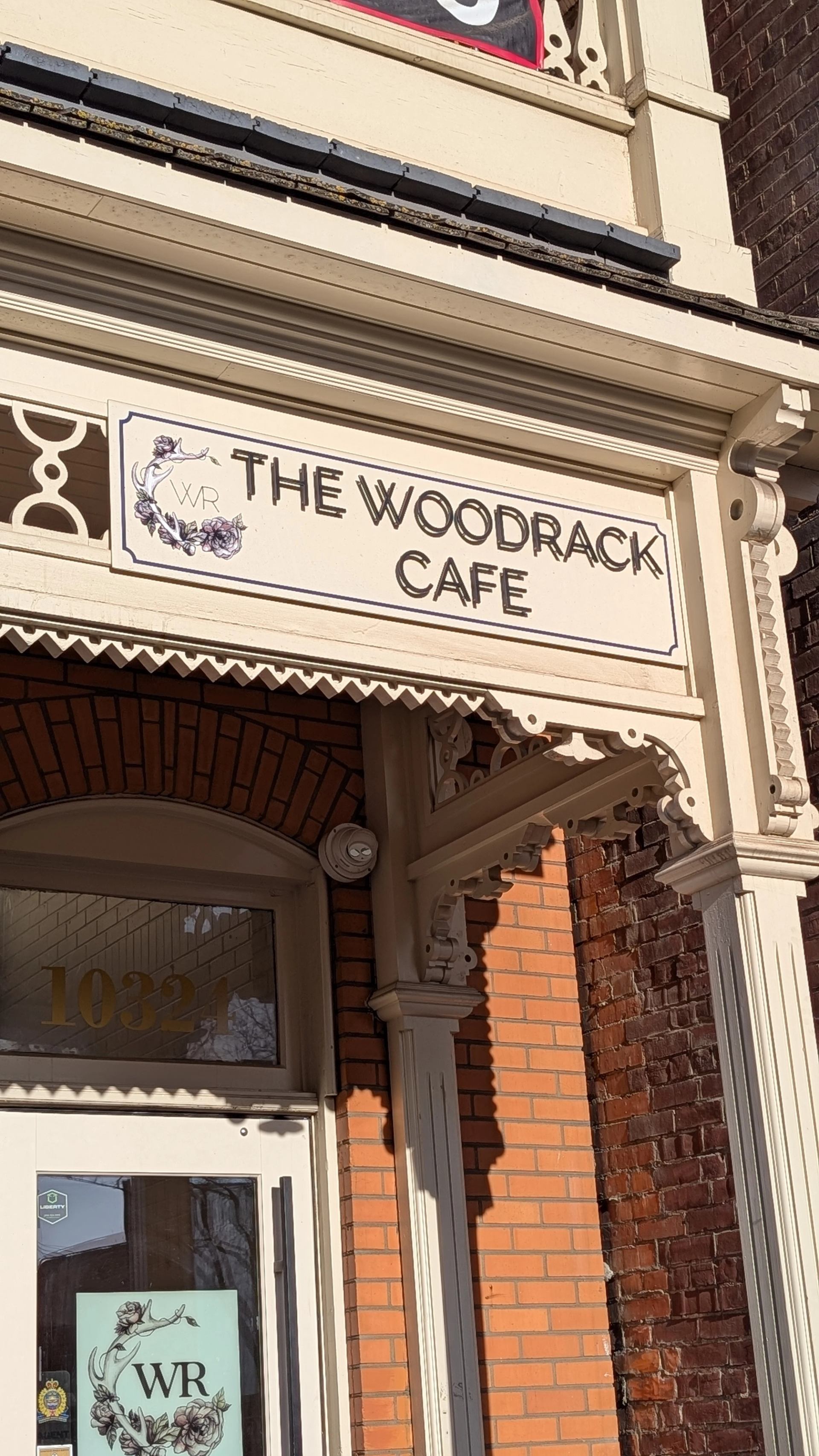 Woodrack Cafe entrance with decorative cream trim on a brick building facade.