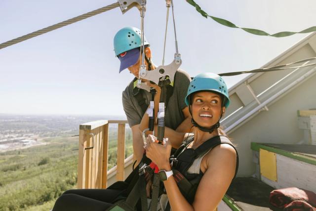 A guest gets clipped in to her harness before ziplining at WinSport in Calgary.