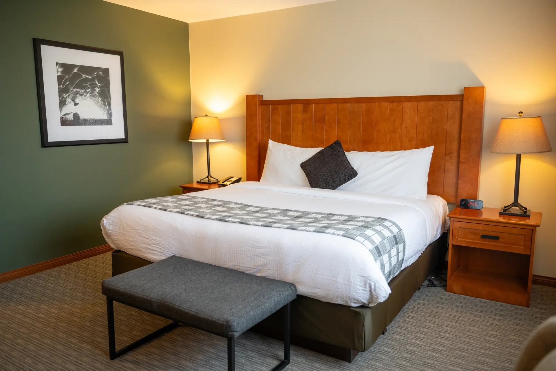 Whistler’s Inn offers restful charm with soft lighting, plaid accents, and a welcoming bedroom retreat.