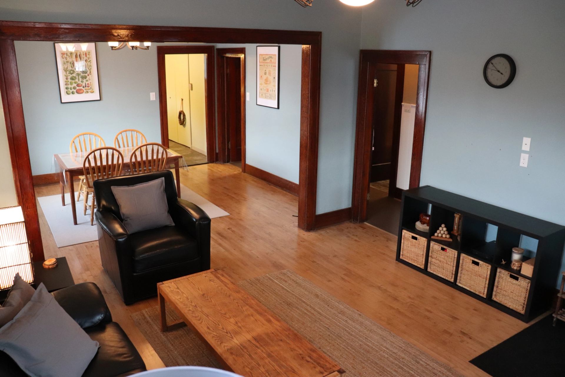Open living area with black armchair, wooden table, and dining space in view.