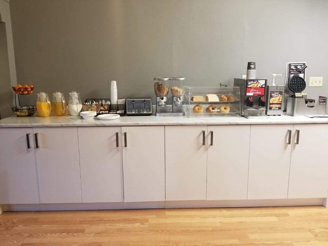 Travelodge by Wyndham breakfast bar with juice, coffee, pastries, and cereal.