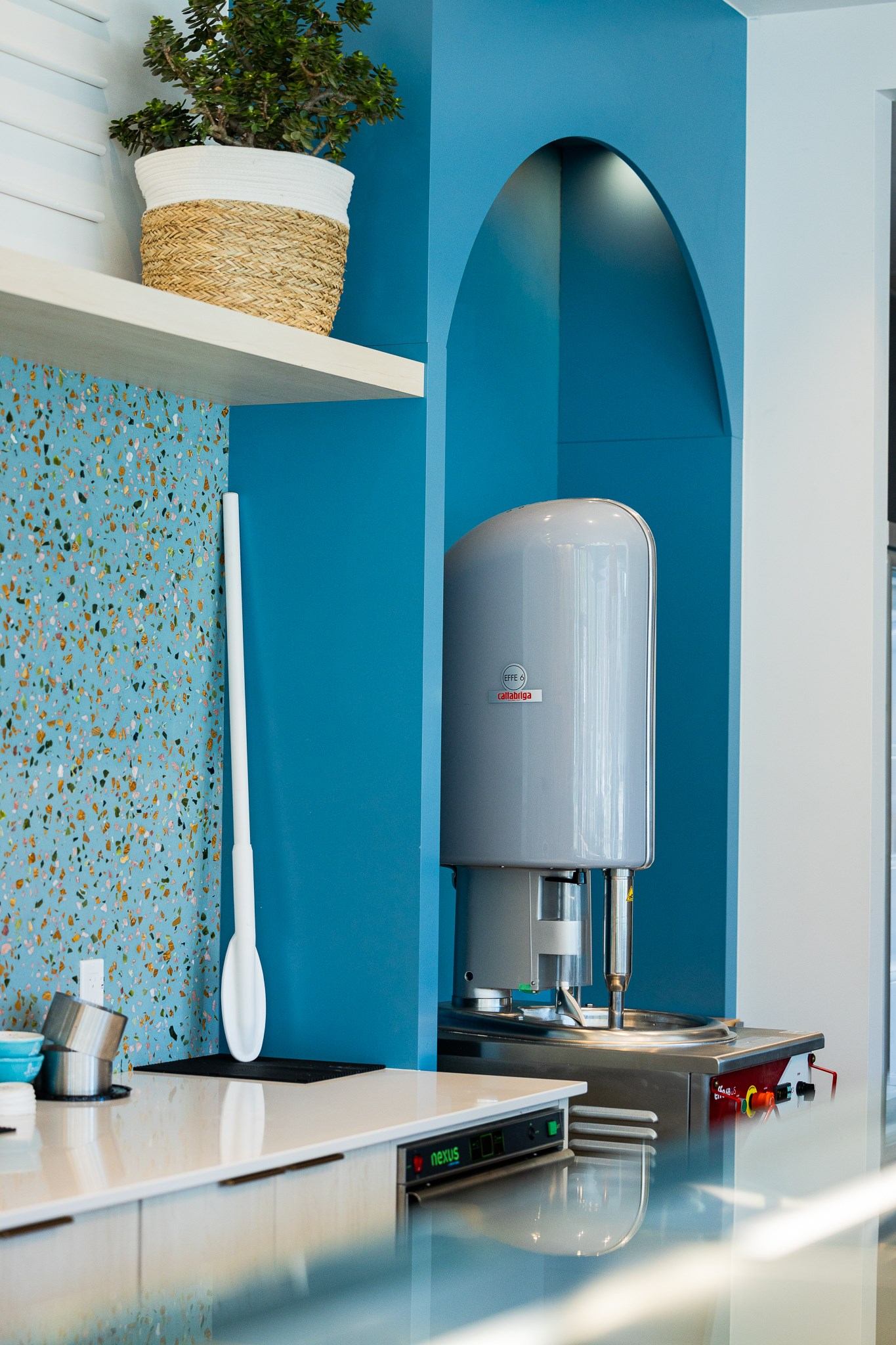 Ice cream machine set into a blue alcove inside a modern Lovely Ice Cream shop.