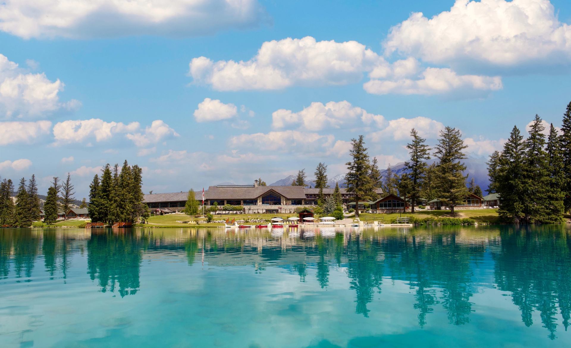 A scenic, summer view of Fairmont Jasper Park Lodge as seen from Lac Beauvert.