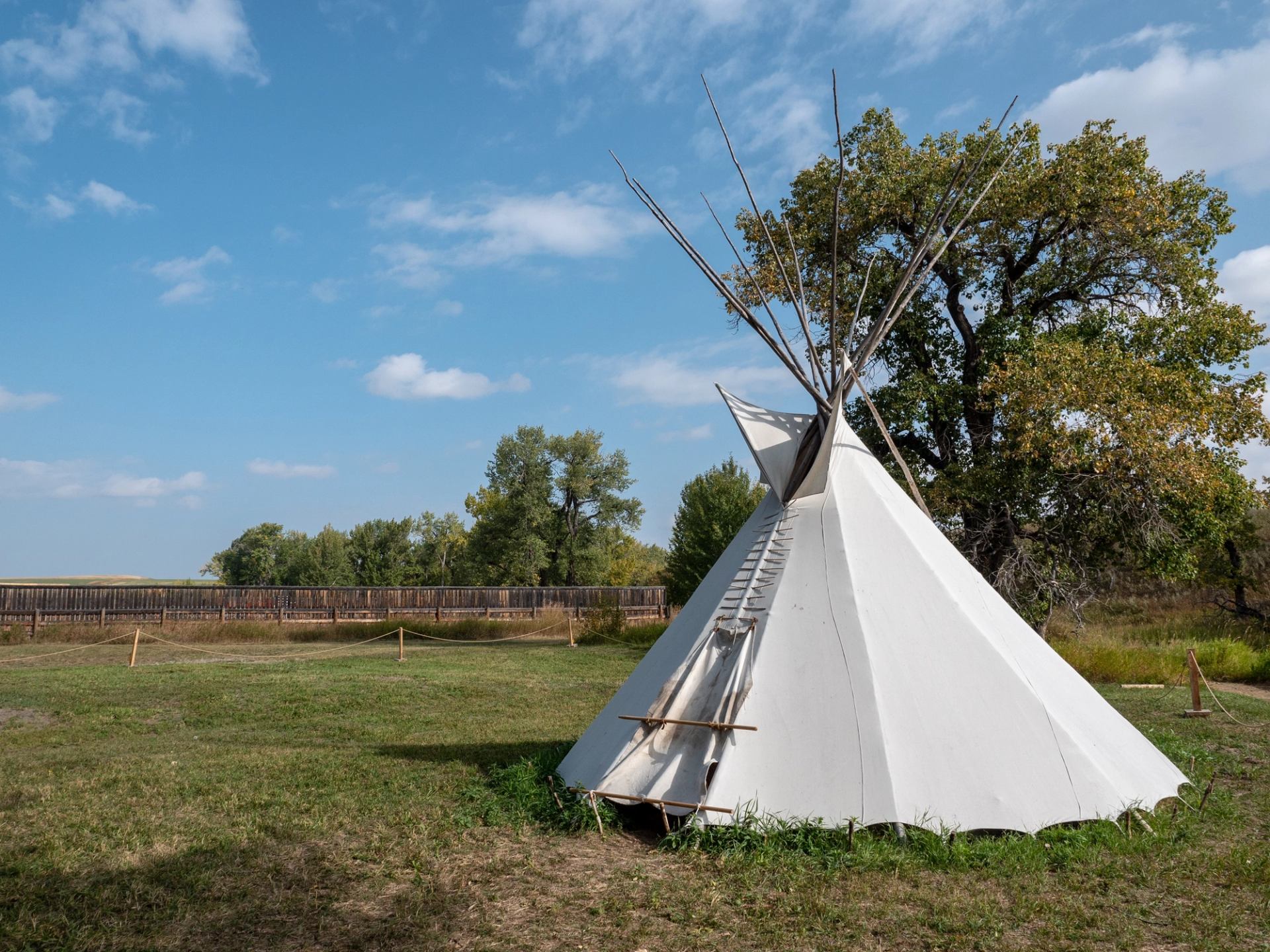 A raised tipi in a grassy field at Bar U Ranch National Historic Site.