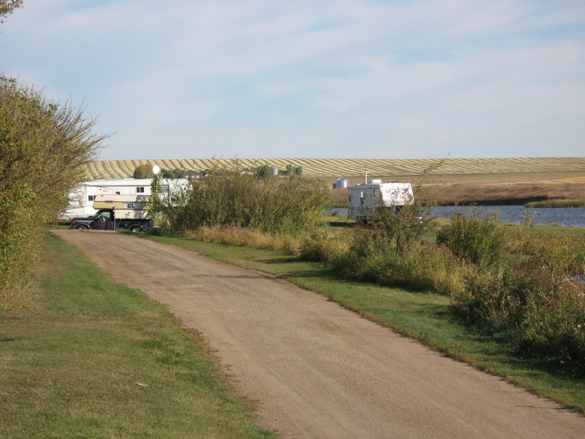 Two RVs parked by the water