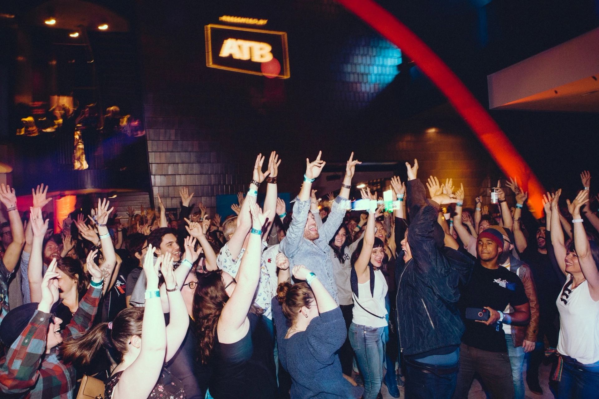 Crowd dancing and raising hands at Block Heater music event.
