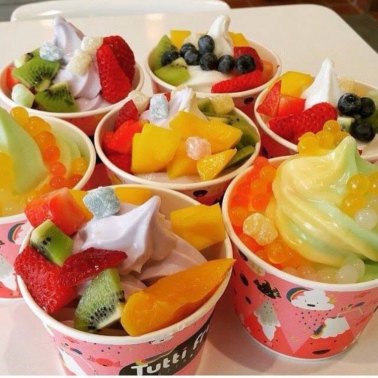 Colourful frozen yogurt cups topped with mixed fruit, jelly cubes and popping boba.