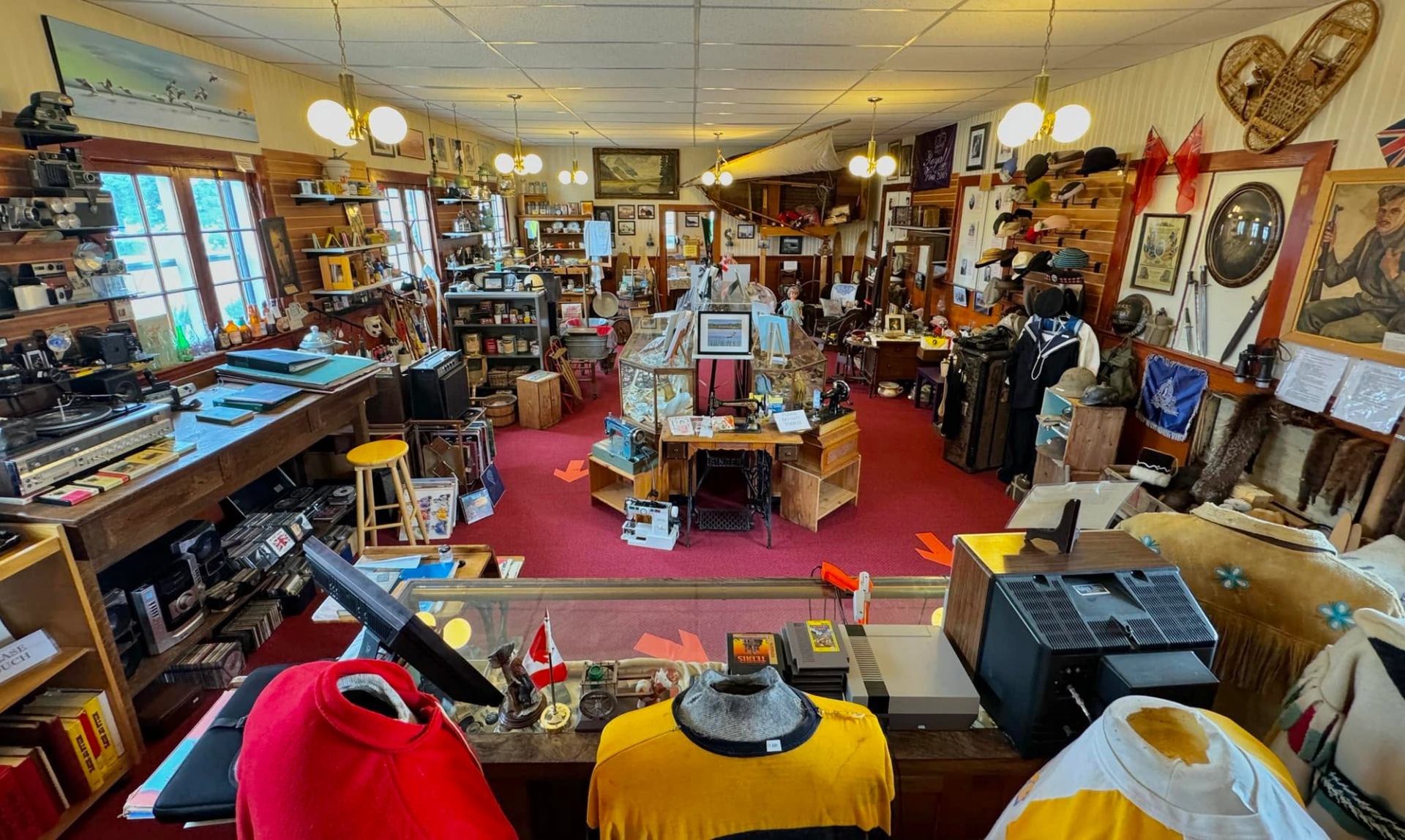 Museum gallery filled with historical artifacts, display cases, photographs, and vintage objects.