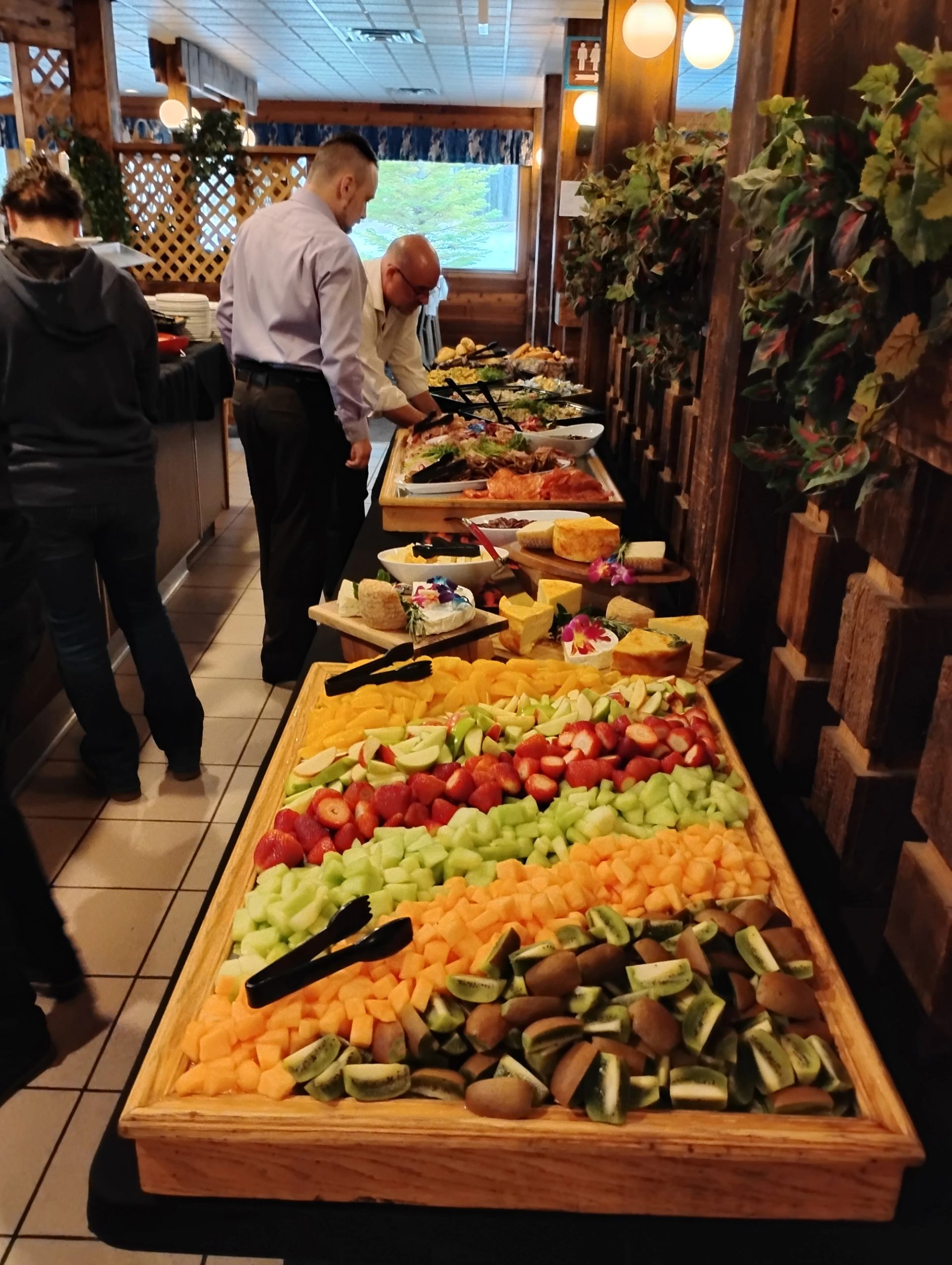 Buffet table filled with sliced fruit and assorted dishes at The Crossing Resort.