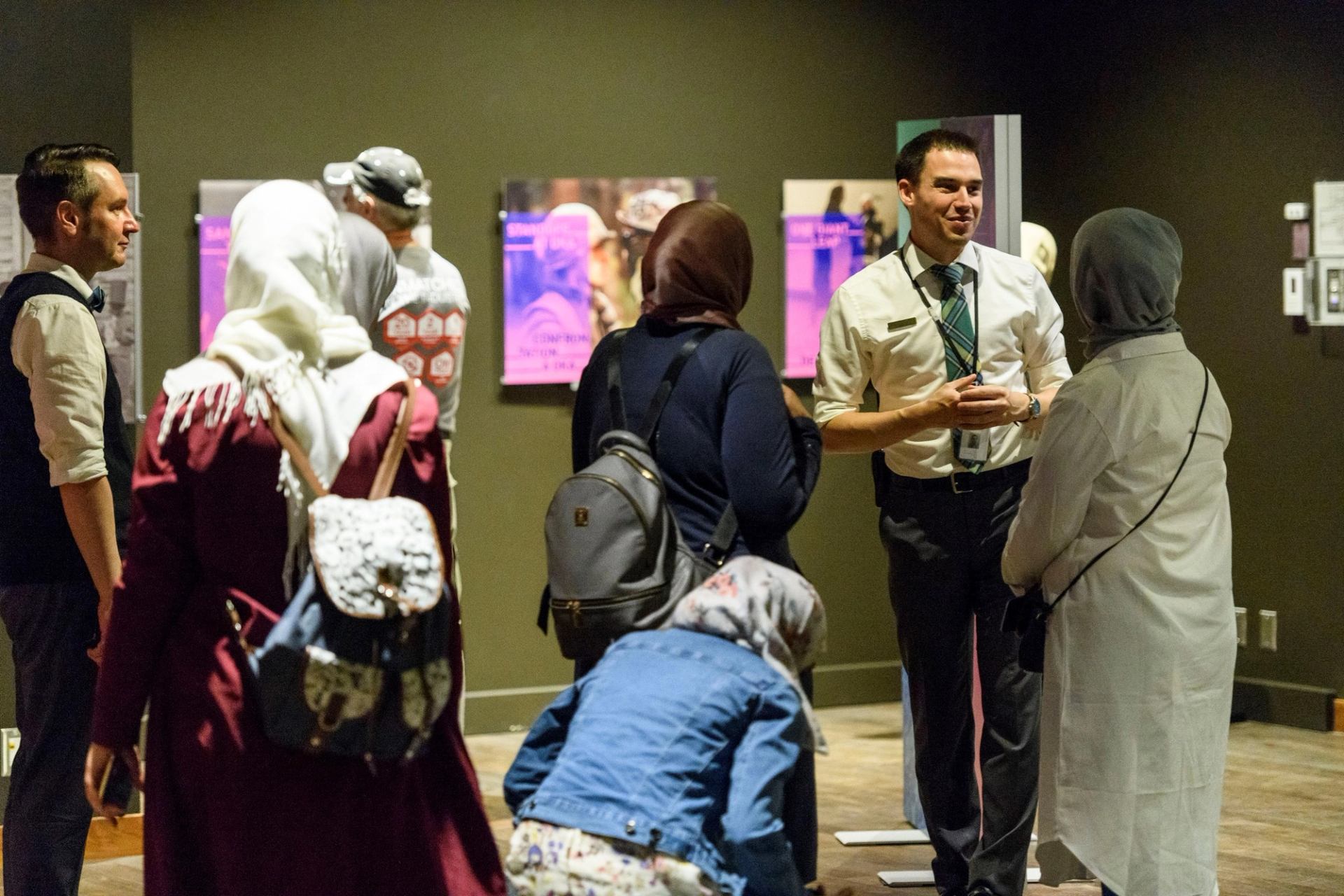 Visitors explore exhibits in a dimly lit gallery at Alberta’s Legislative.
