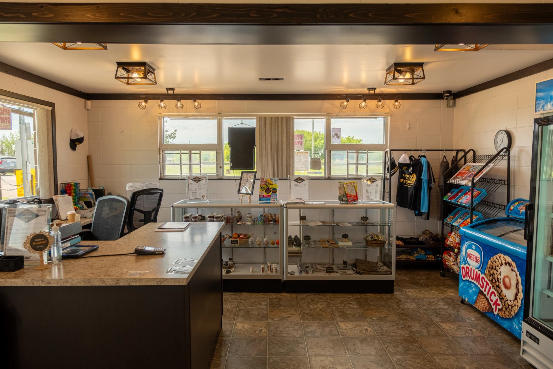 Interior of info centre with counter, display cases, and ice cream freezer.