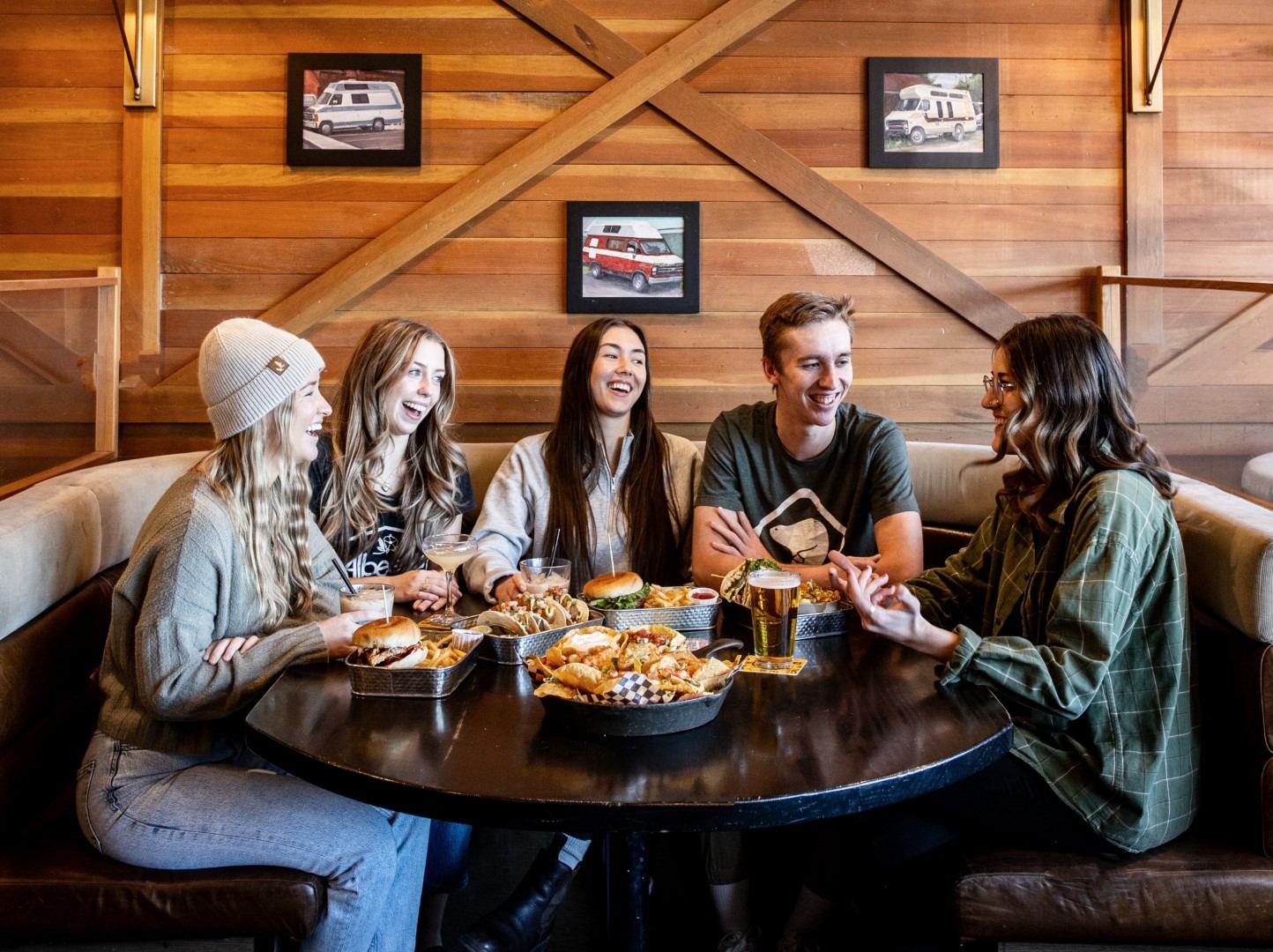 Friends enjoying a meal together at a cozy restaurant table with spring-inspired dishes.