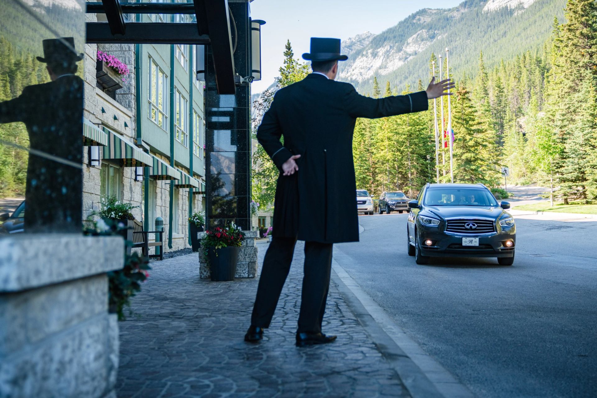 Doorman greets car at the front of Rimrock Banff