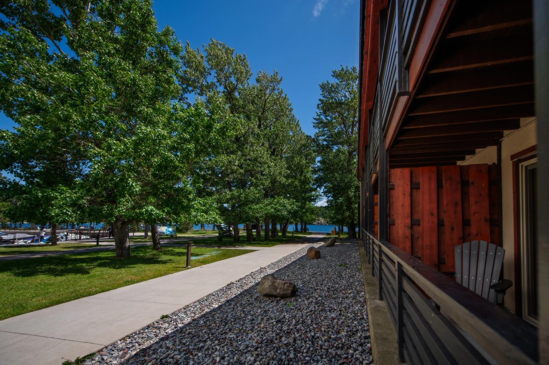 Tree-lined path beside the Bayshore Inn building with lake views in the background.