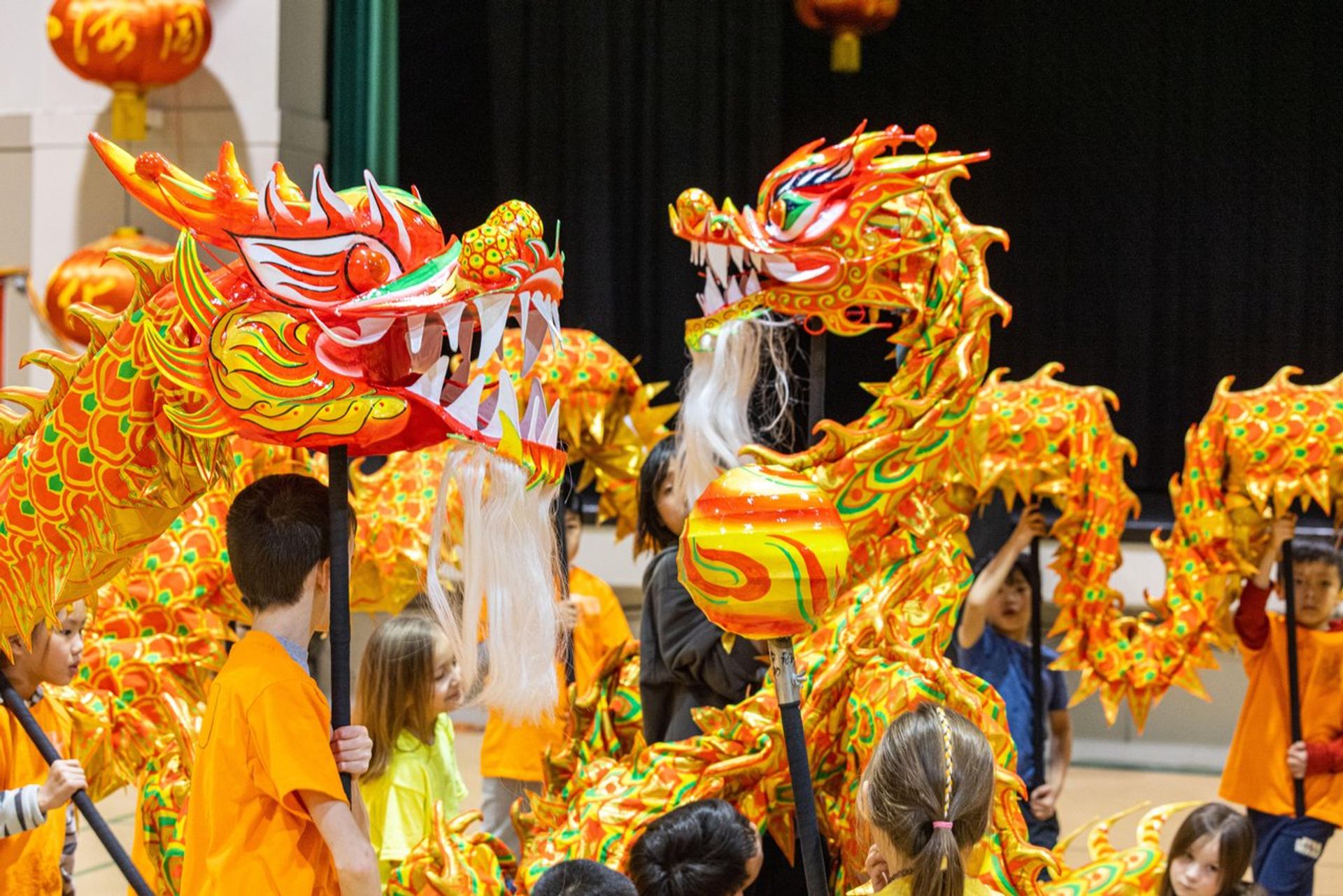 Colorful dragon dance performance with bright orange and gold dragon figures.