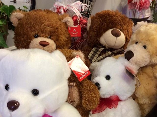 Stuffed teddy bears in white, brown and beige colours displayed closely together indoors.
