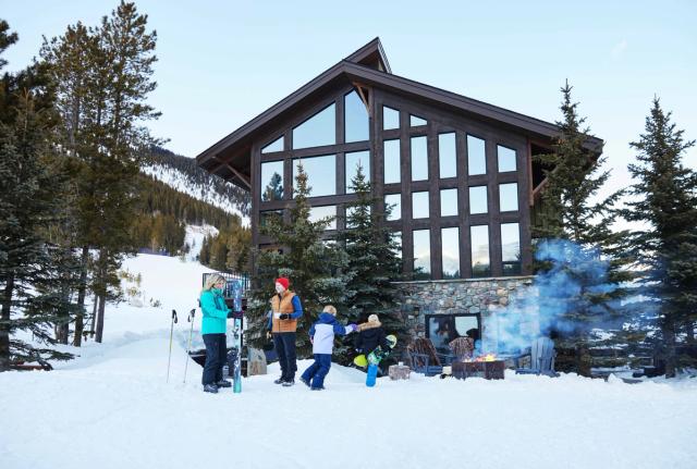 A family at the base of the hill, gear off after skiing Castle Mountain Resort.