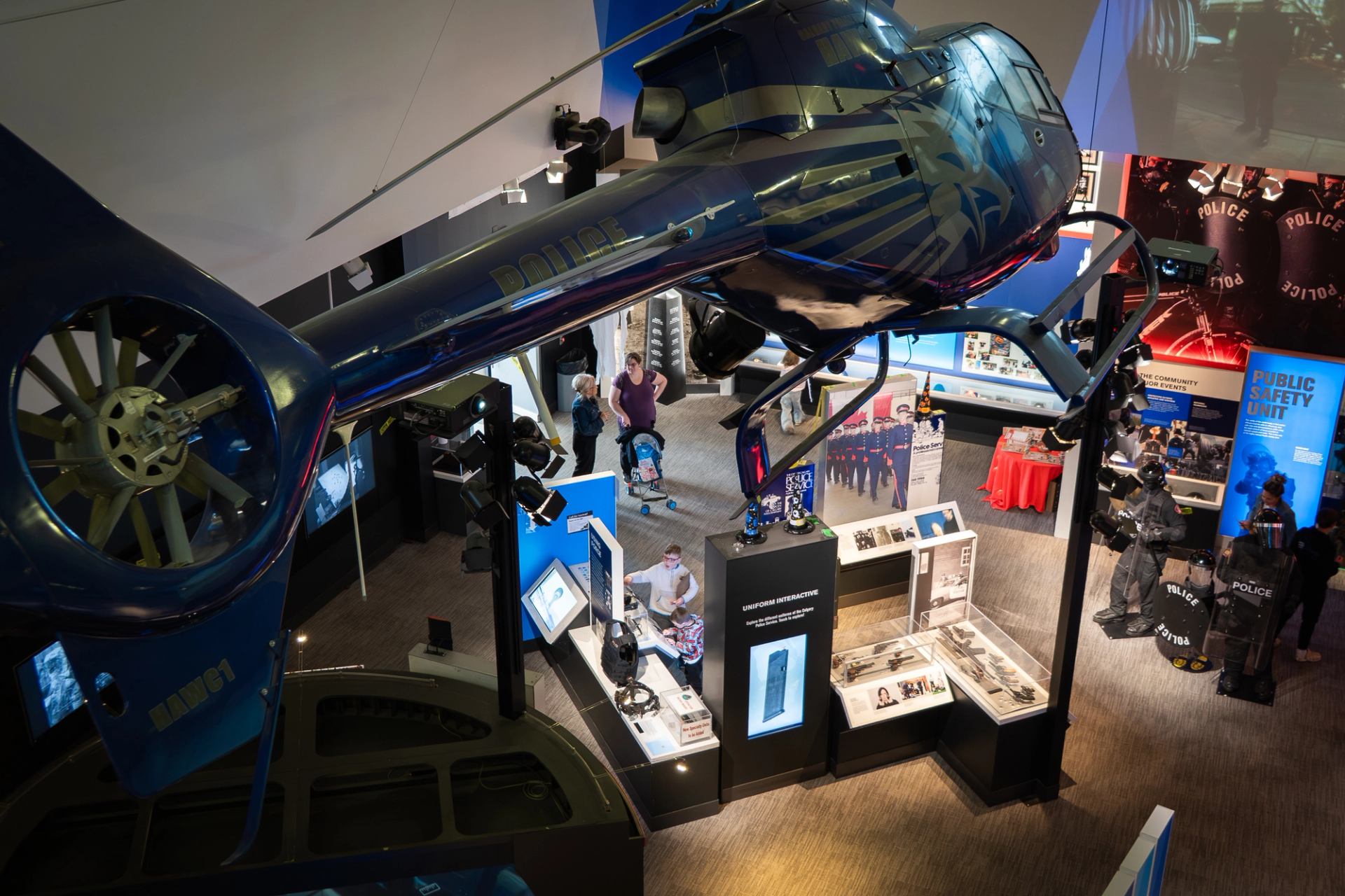 arge blue helicopter suspended above interactive displays in a museum setting