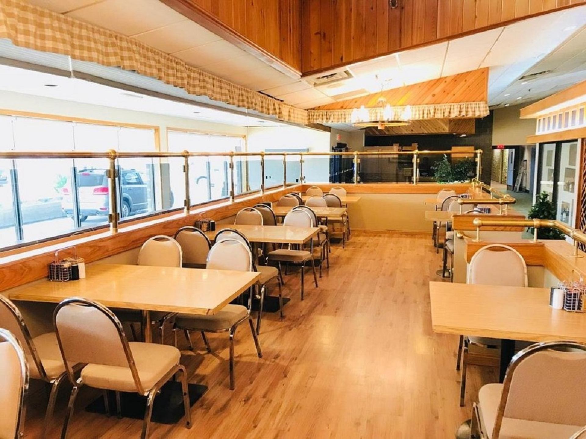 Cozy dining area with wooden floors, tables, and large windows at Hotel Northern Star.