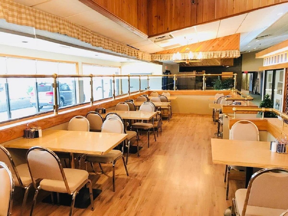 Cozy dining area with wooden floors, tables, and large windows at Hotel Northern Star.