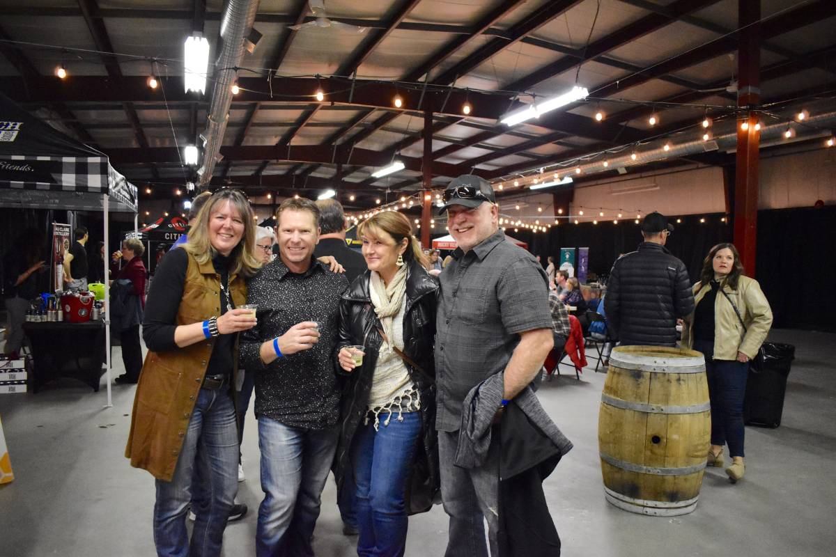 A group of people having their picture taken with a drink in their hand