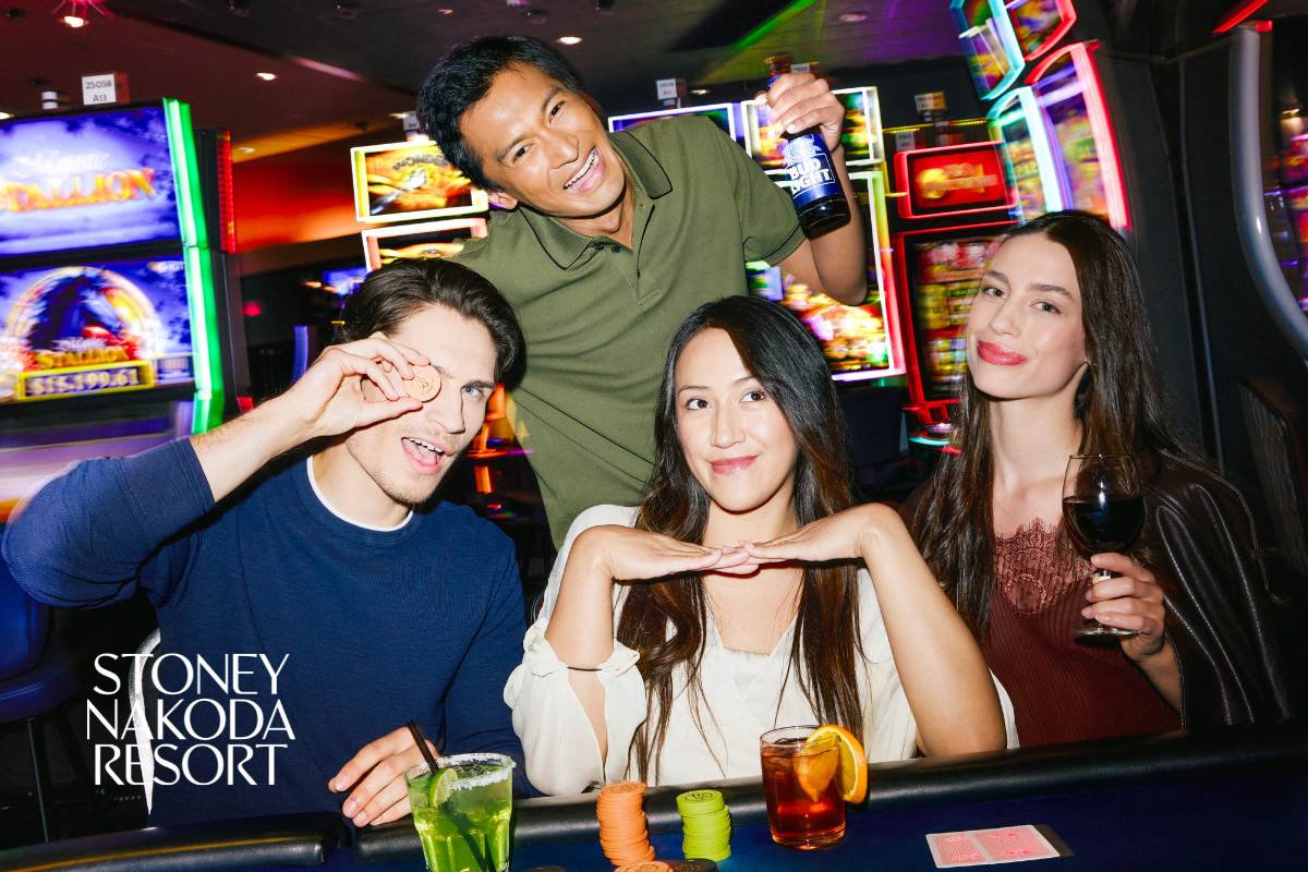 Group enjoying drinks and games at a brightly lit casino inside Stoney Nakoda Resort.