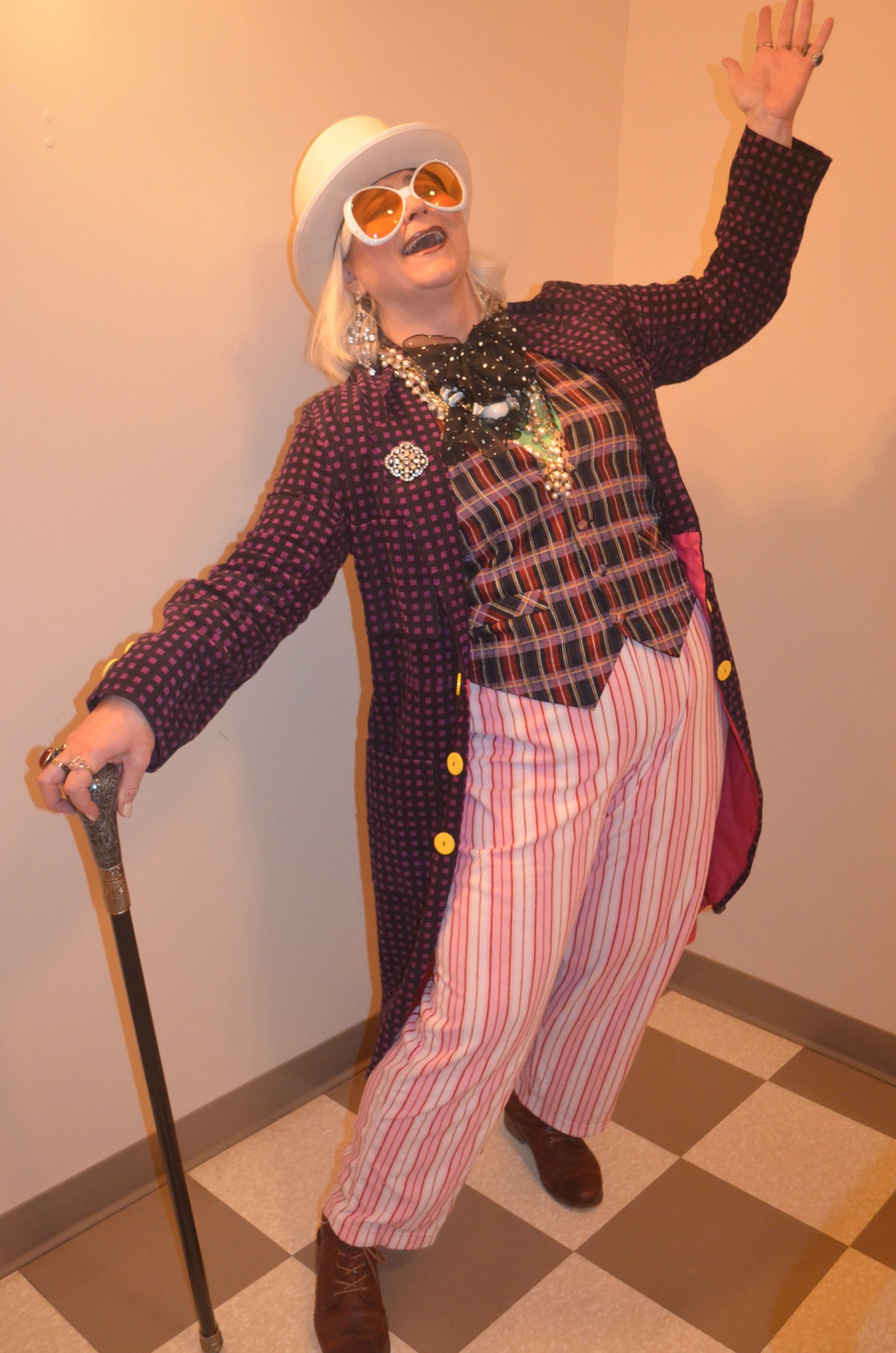 Actors performing a comedic mystery scene at a dinner theatre with tables, costumes, and stage lighting.