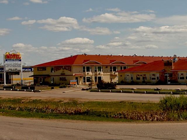 Western Budget Motel with red roof and roadside sign under a blue sky.