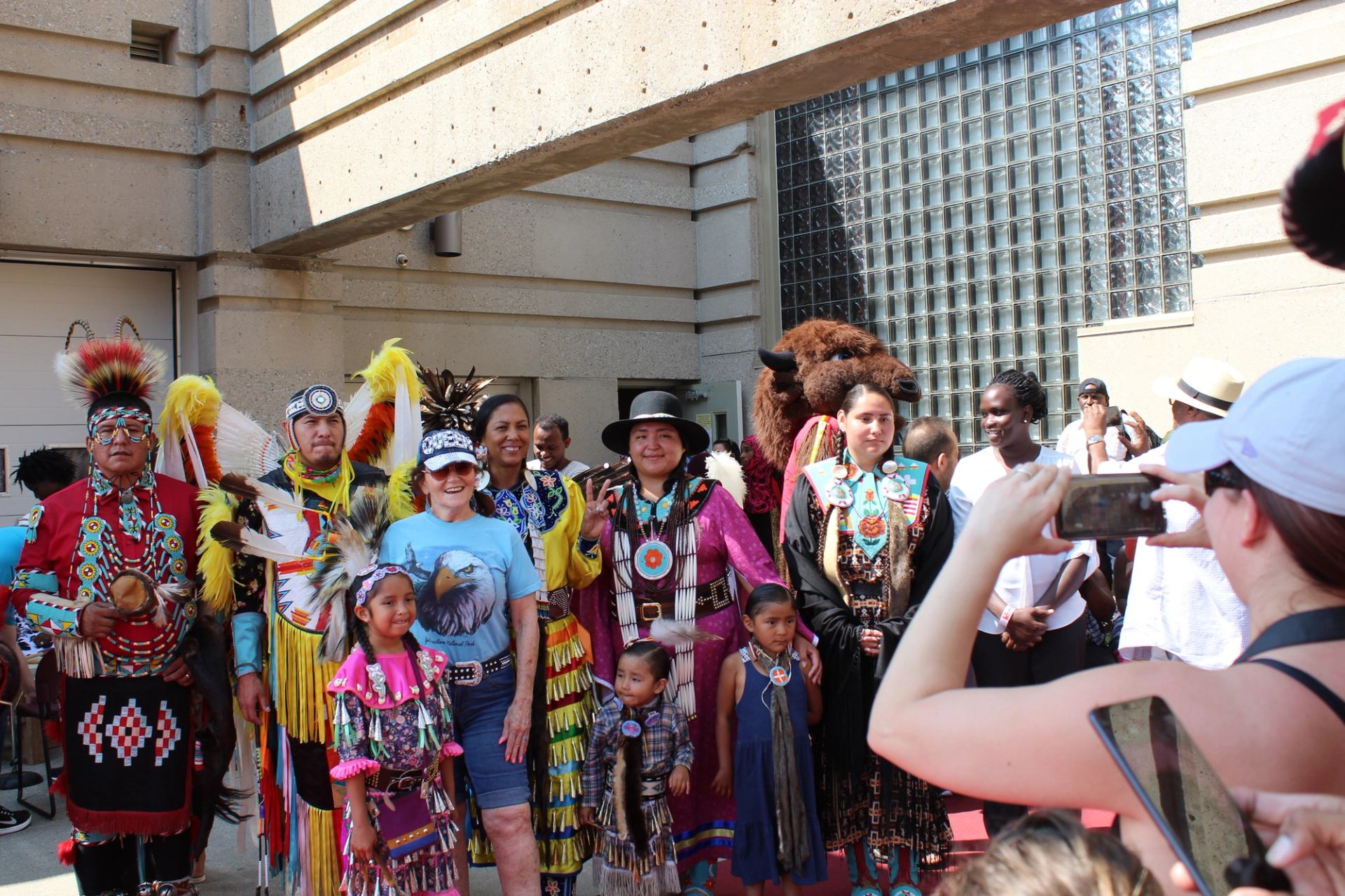 Cultural gathering with colorful outfits and photo being taken.