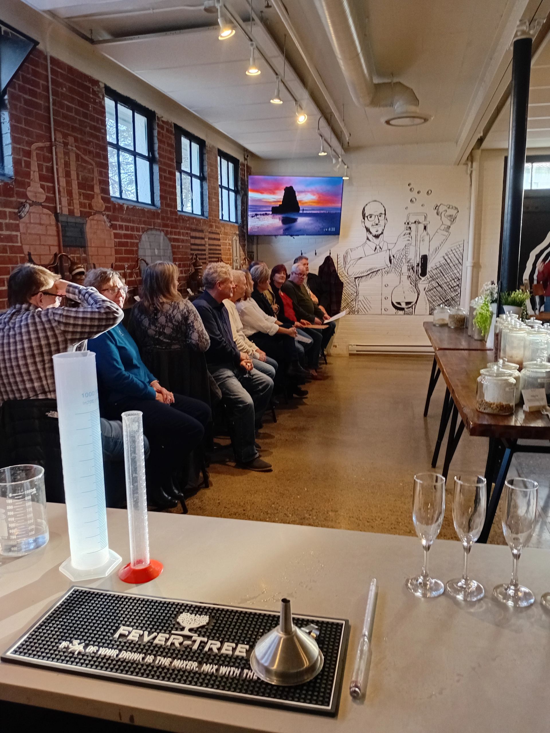 Seated group beside laboratory glassware in an industrial-style room.