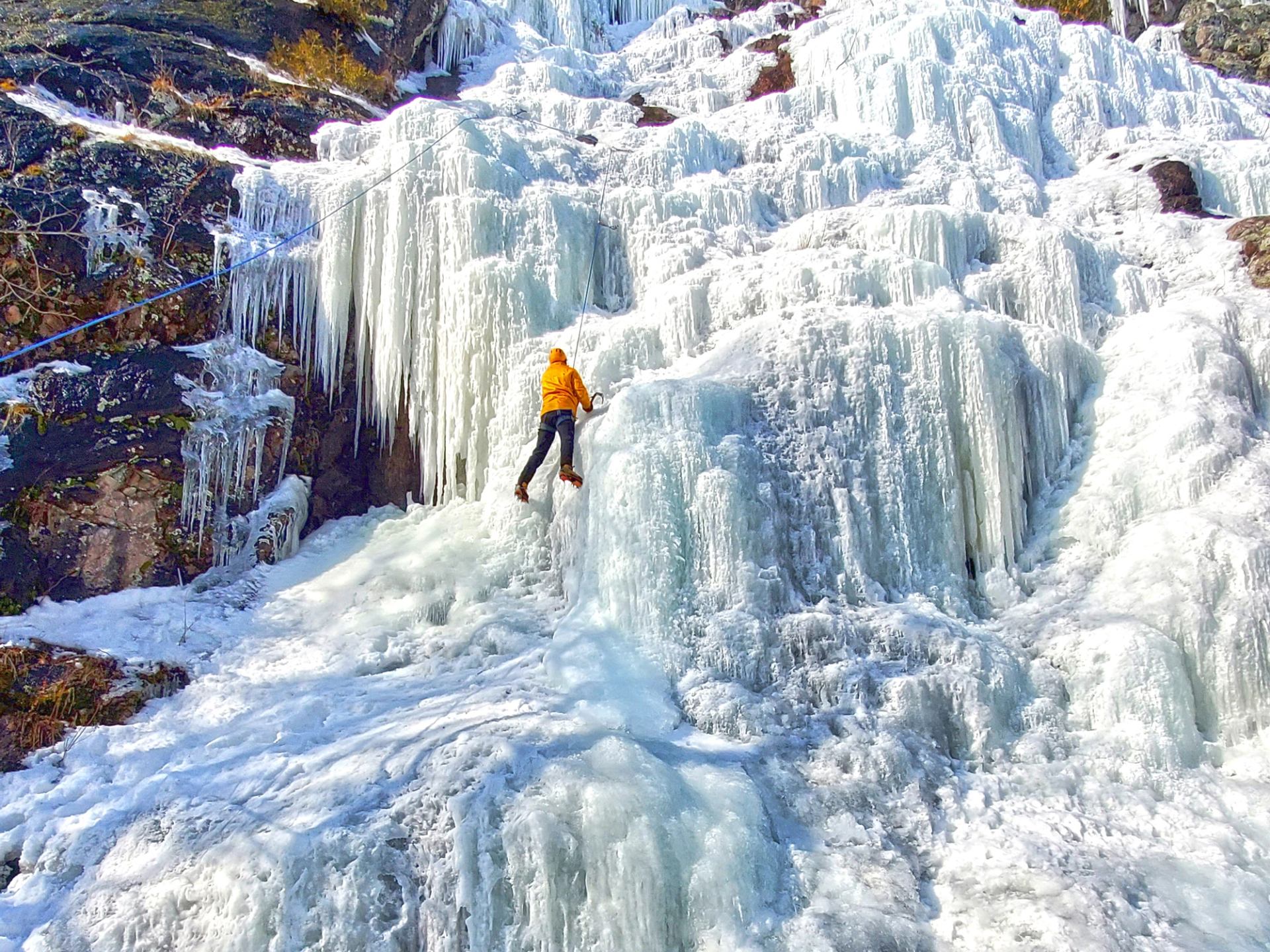 climber in yellow jacket learning to ice climb