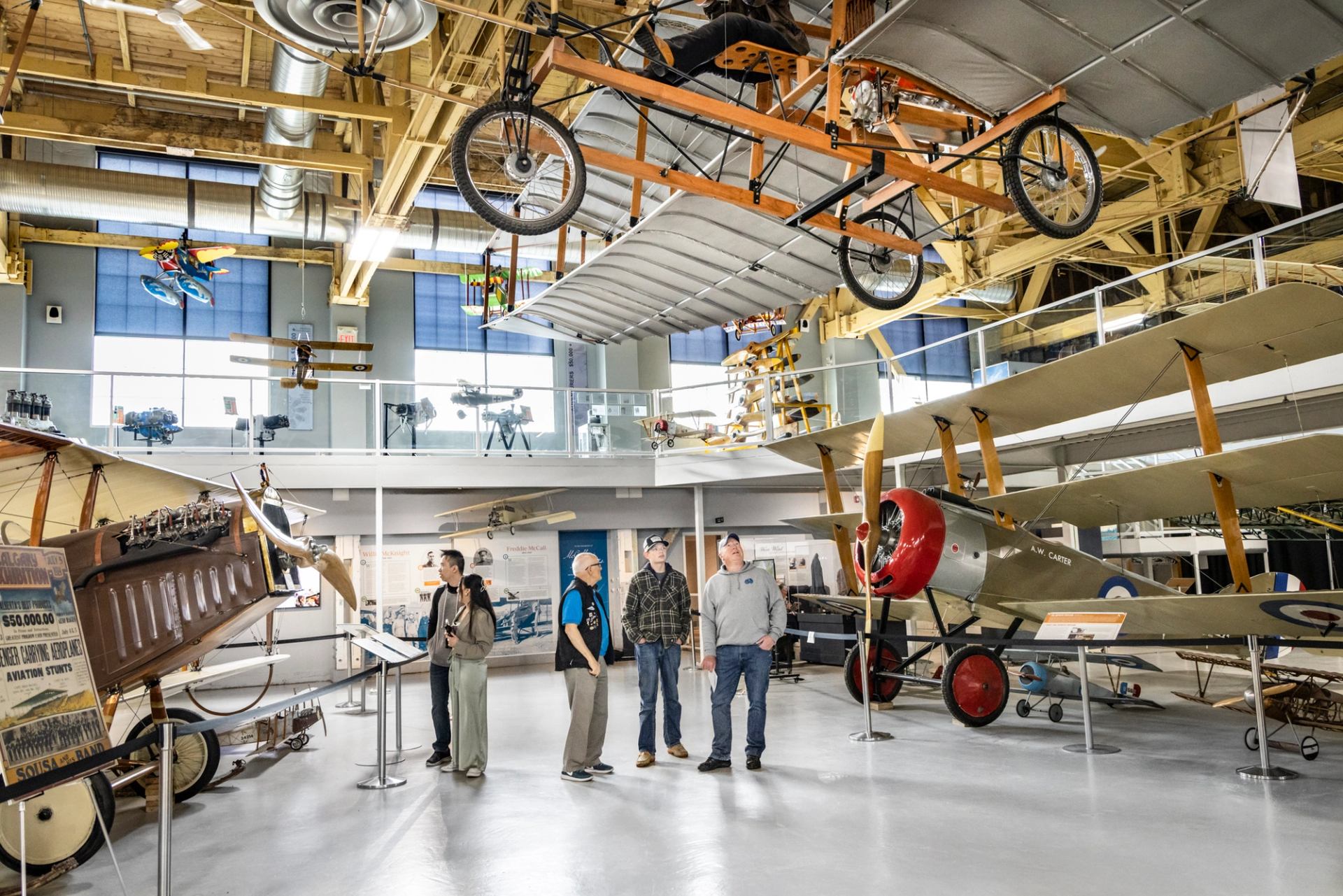 People view early aviation exhibits and hanging aircraft