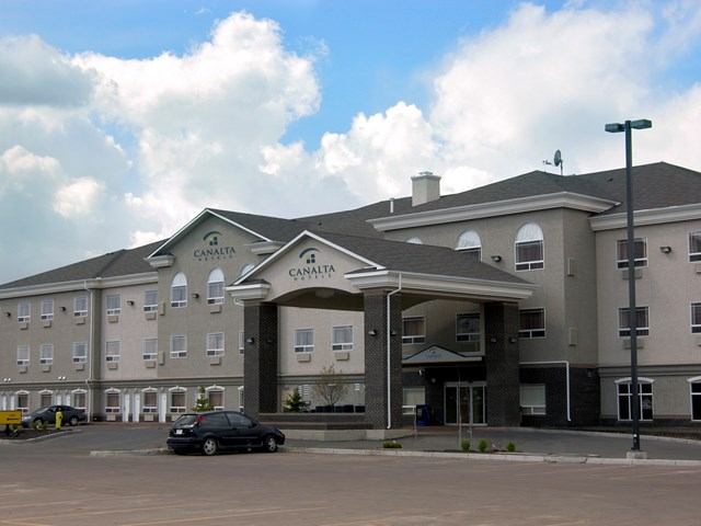 Exterior of Canalta Camrose hotel with entrance canopy and parked cars.