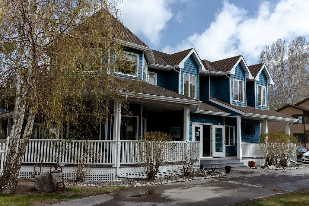 Lady MacDonald Country Inn blue house with porch, railings, and windows beside a driveway.