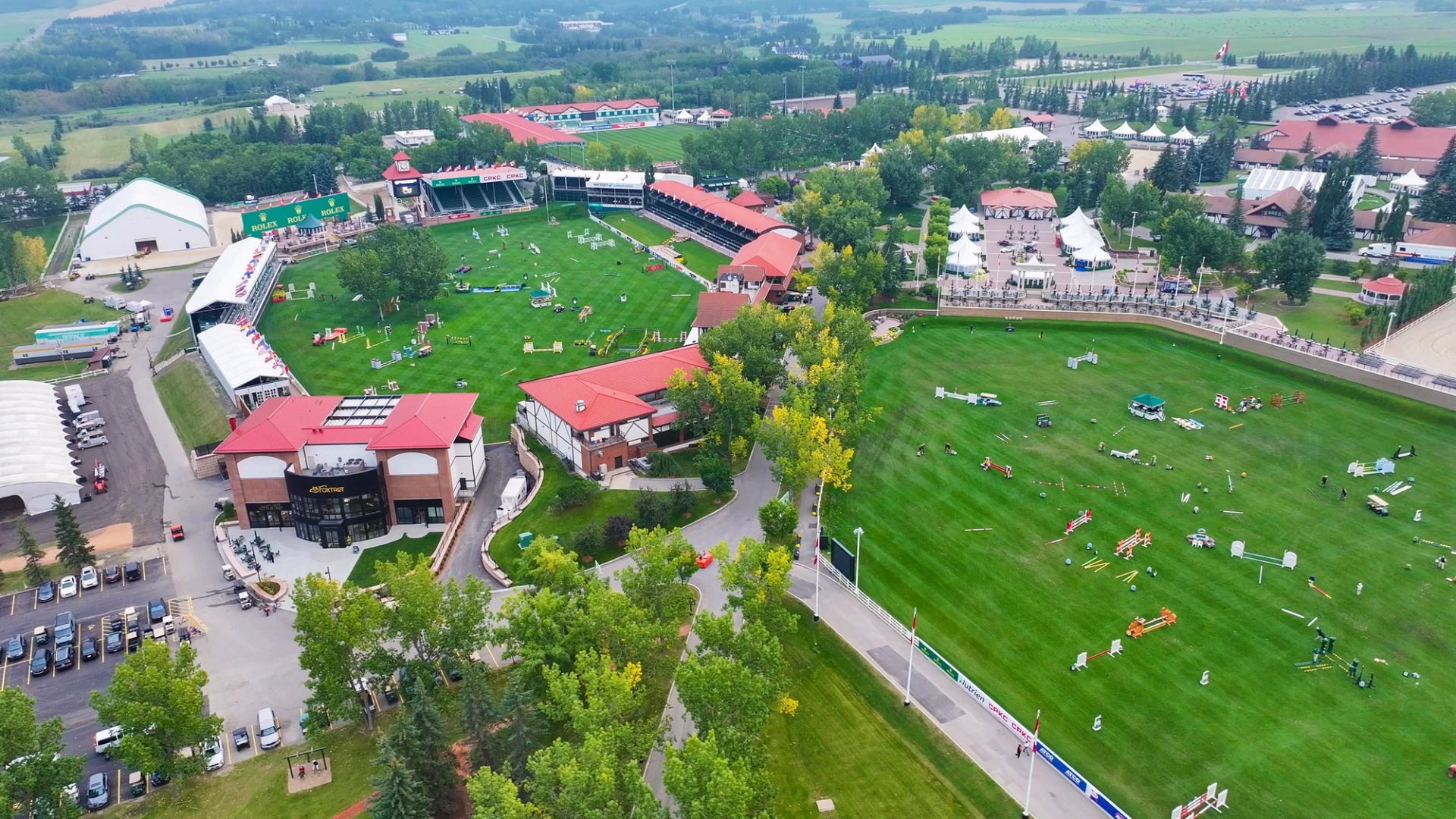 Aerial view of Spruce Meadows showing green fields, arenas, pathways, and surrounding buildings.