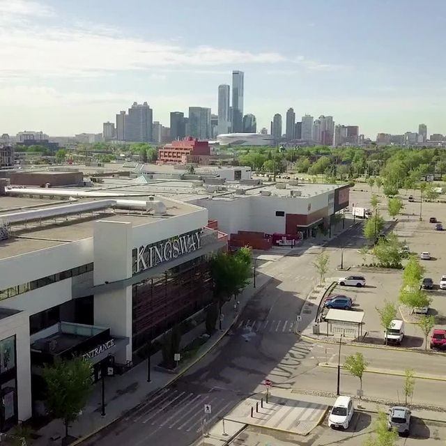 Kingsway Mall exterior with storefronts and parking lot in Edmonton skyline view.