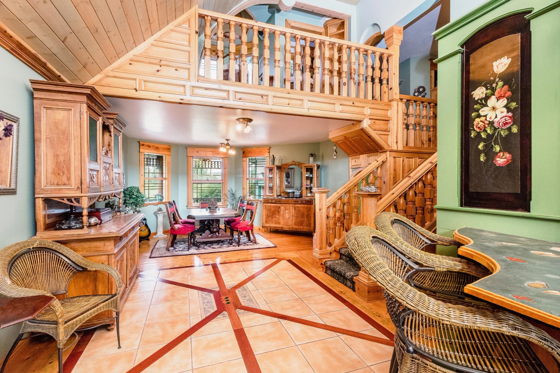 Bright dining area with wood accents, staircase, and elegant furniture.