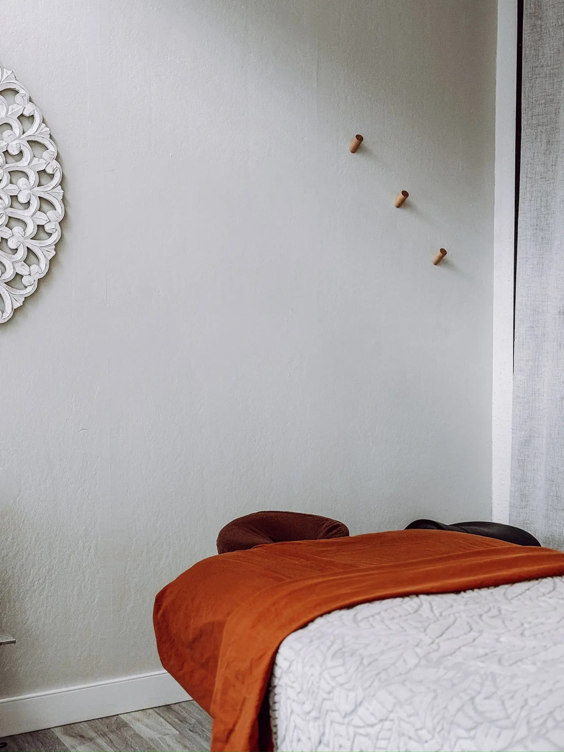 Massage bed with warm blankets in a calm, softly lit spa room.