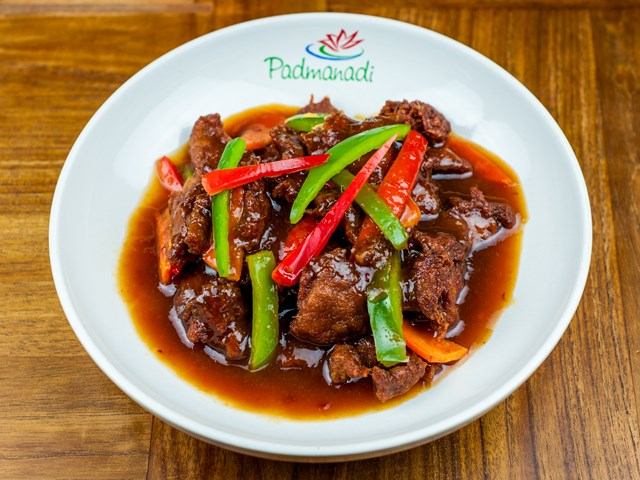 Bowl of saucy plant-based protein with bell peppers at Padmanadi.