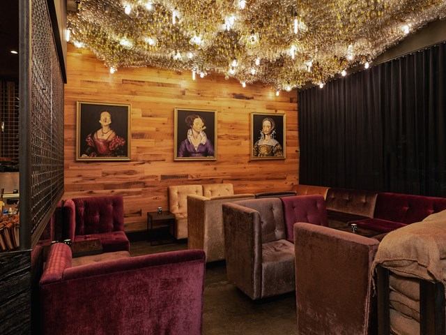 Seating area with royal portraits and floral ceiling lights